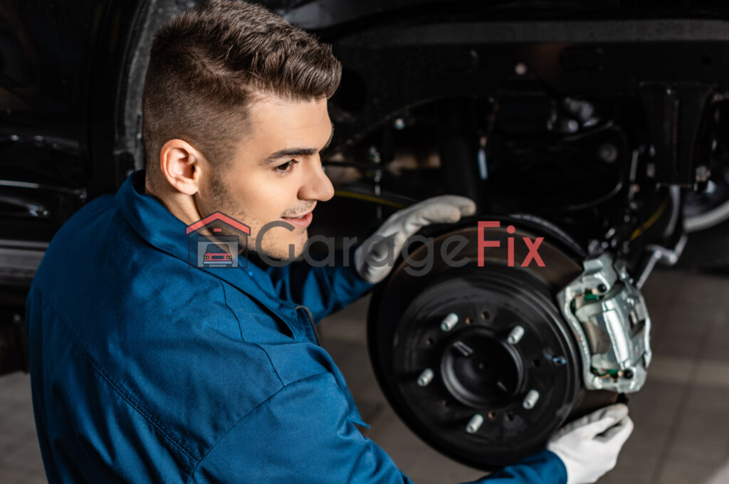 A mechanic working on the brakes of a car.