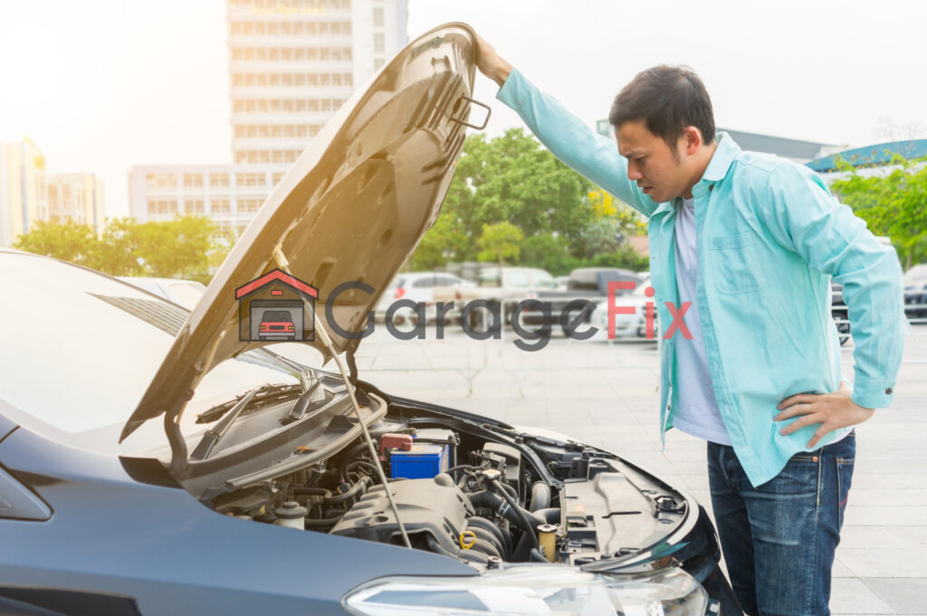 A man looking under the hood of a car.