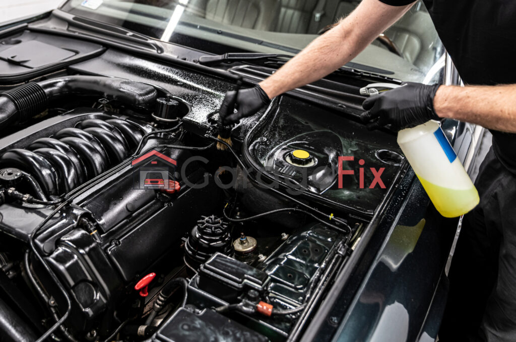 A man is cleaning the engine of a car.