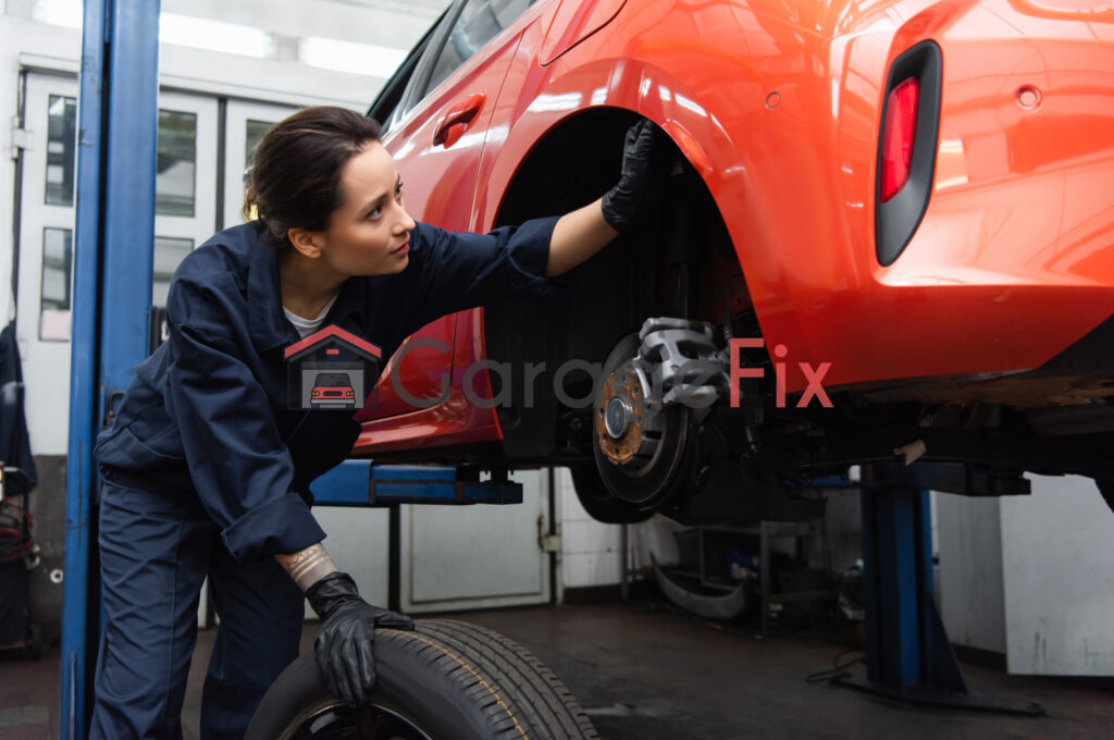 A female mechanic working on a car tire.