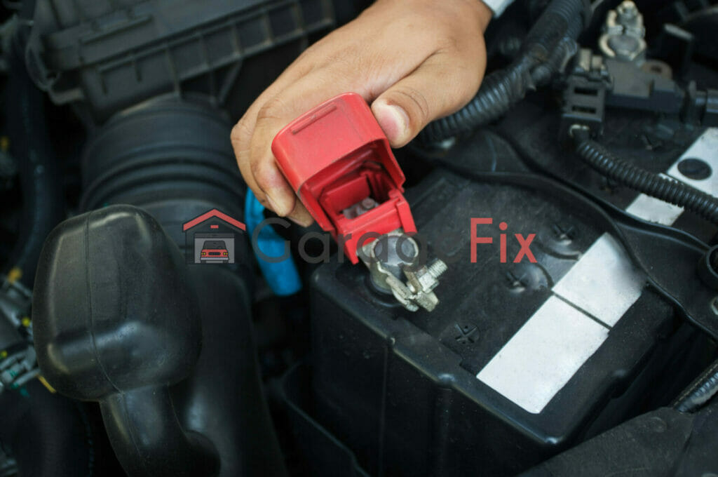 A person is putting a red battery on a car.