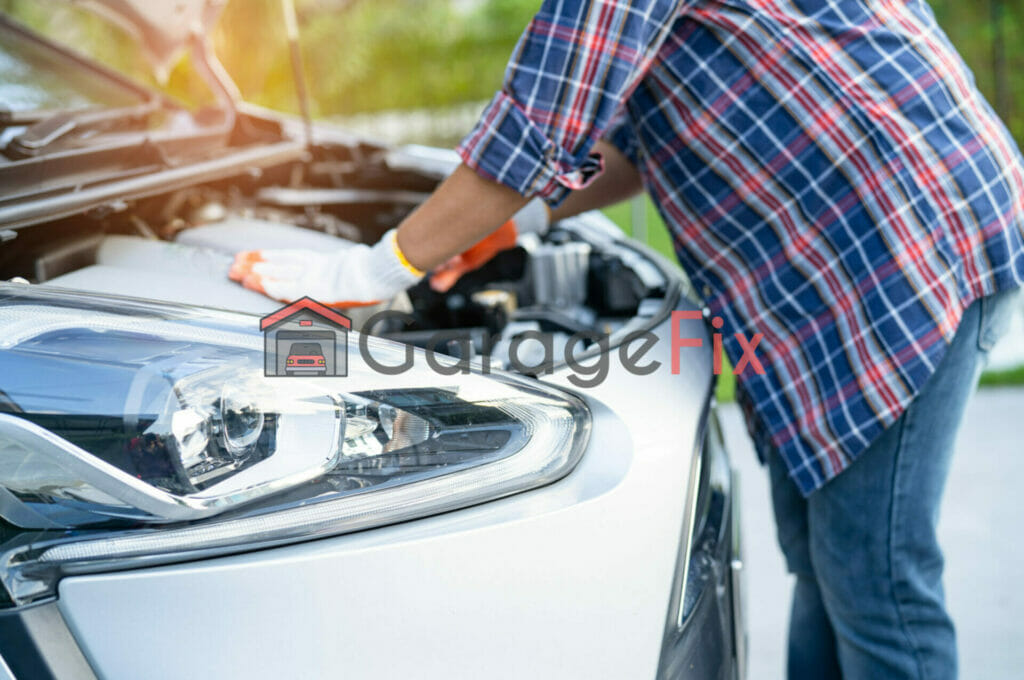 A woman is working on the hood of a car.