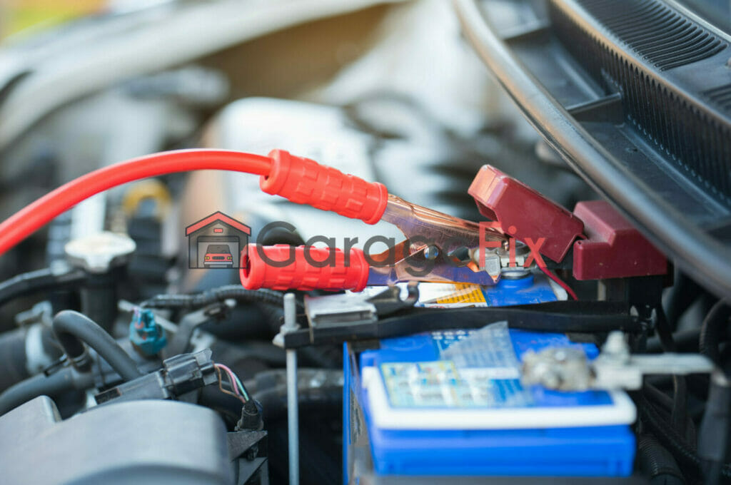 A car battery is connected to the hood of a car.