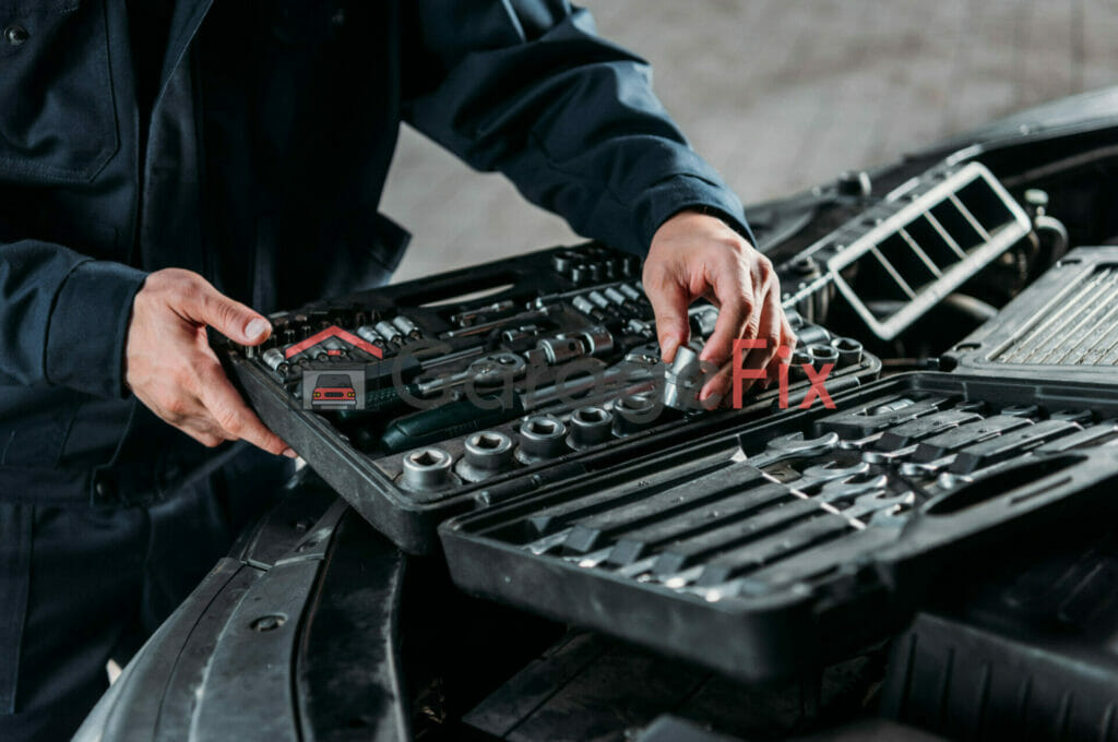 A mechanic working on a car with a tool box.