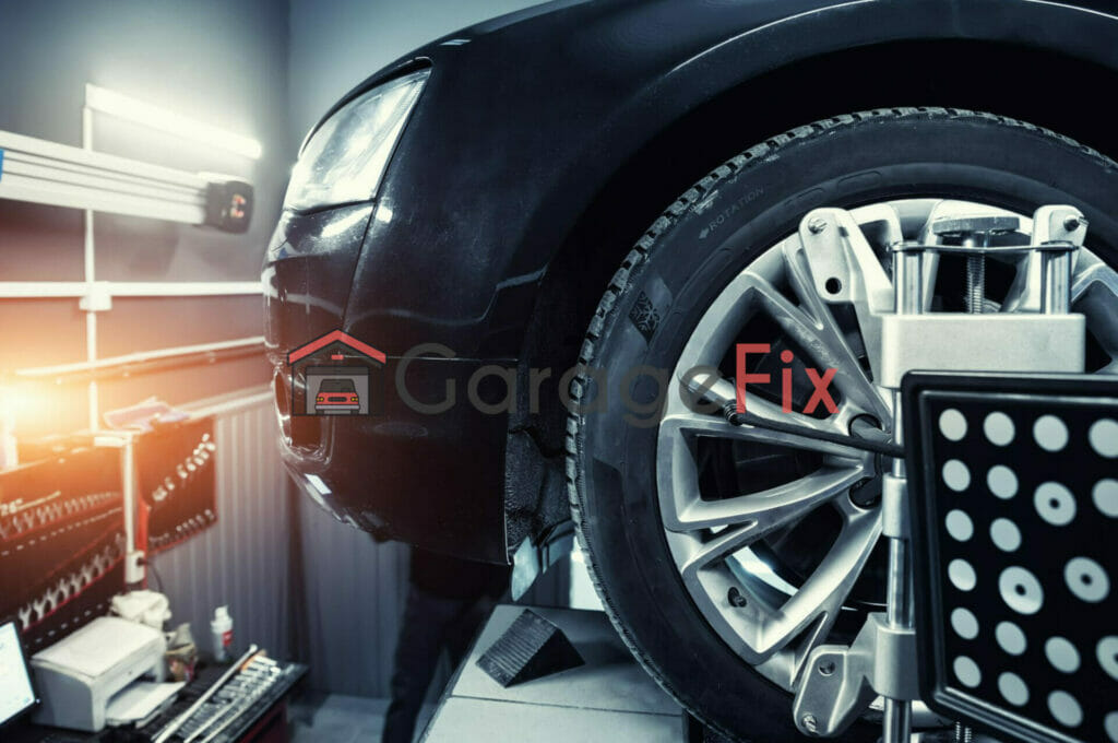 A black car with a tire on it in a garage.