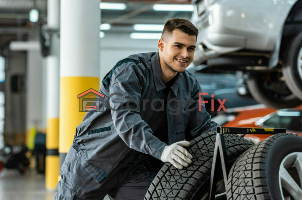 A mechanic working on a tire in a garage.