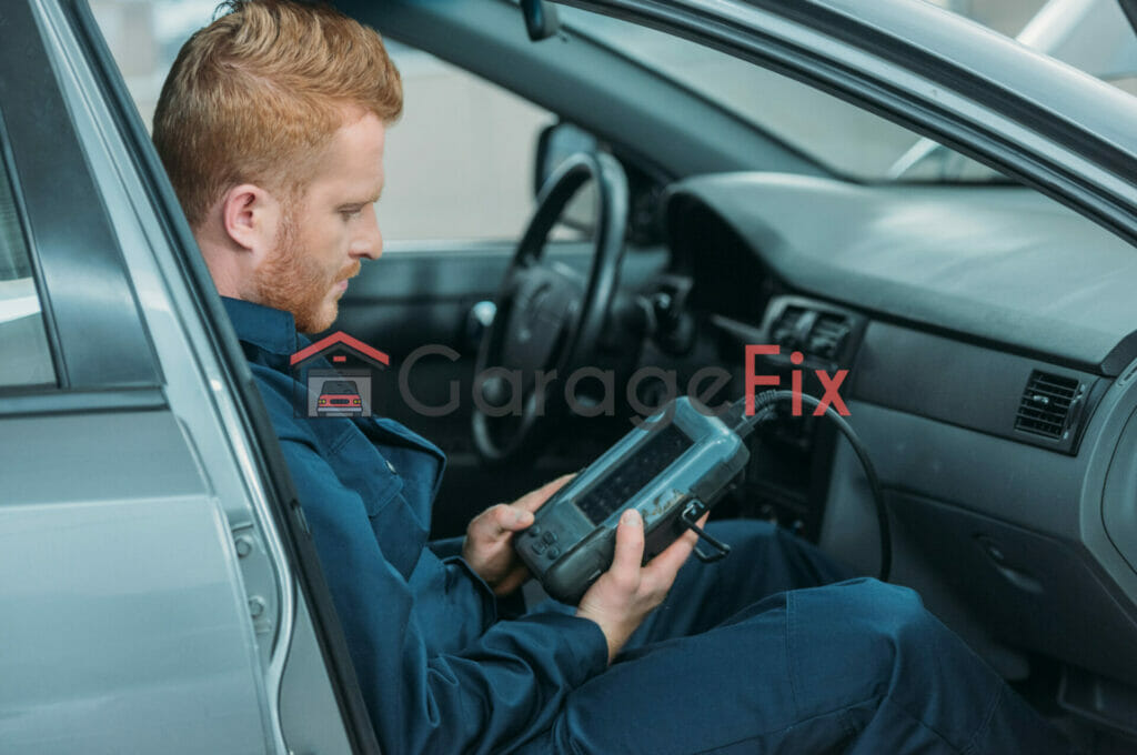 A man in a blue shirt is using a tablet in his car.